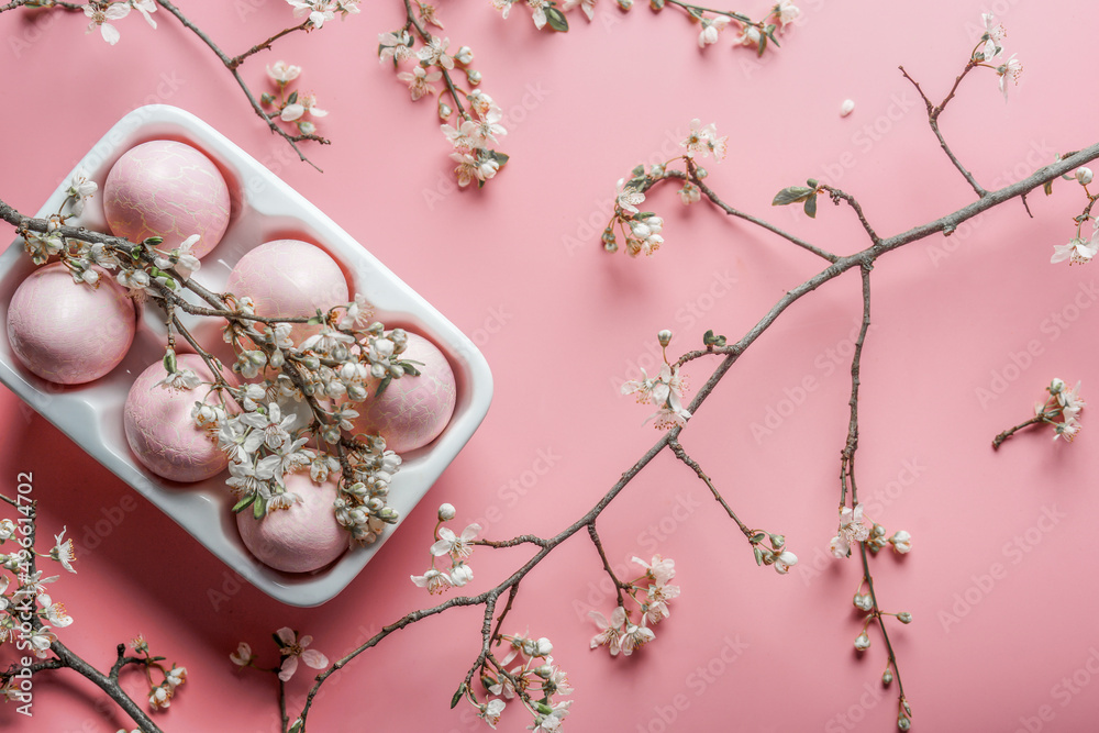 Pink Easter eggs in white packaging with white cherry blossom branches ...