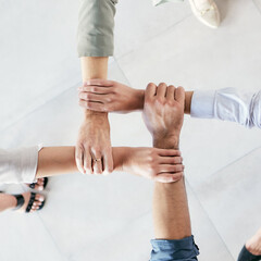 Poster - Developing a good work ethic is key. Cropped shot of a group of businesspeople linking their arms in solidarity at work.
