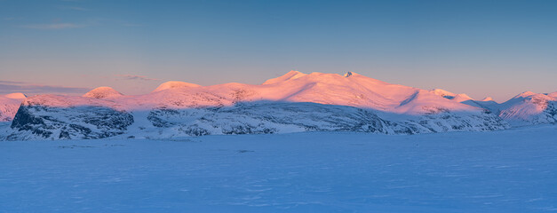 Fototapete - Last, pink, sunlight on the mountains of Swedish Lapland in winter.