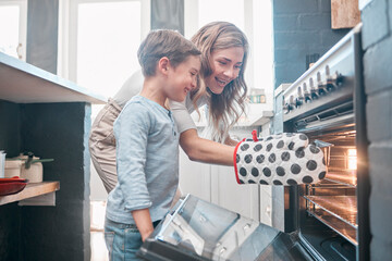 Poster - Cooking and baking is both physical and mental therapy. Shot of a little boy and his mother sitting in front of the oven.