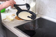 © kosoff - housewife is frying pancakes in a pan.