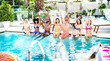 © Mirko Vitali - Side view composition of friends sitting at hotel swimming pool wearing swim clothes - Summer life style concept with trendy people having fun on sunny day at luxury poolside - Bright vivid filter