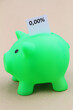 Piggy bank with interest rate 0,00% written on white paper
