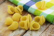 Uncooked pasta on rustic wooden surface, closeup
