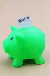 Piggy bank with interest rate 0,01% written on white paper
