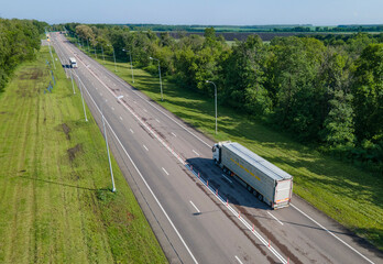 Wall Mural - Truck with Cargo Semi Trailer Moving on Summer Road. Aerial Top View. White vehicle