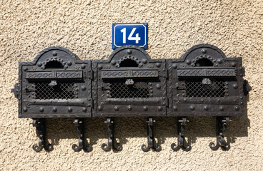 Wall Mural - 14 fourteen house number plate on a concret wall with vintage iron mailboxes next to it