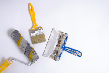 Wall Mural - Paint roller, brush and spatula on a white background, repair tool.