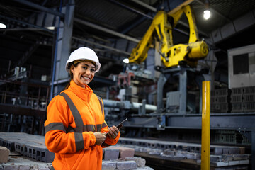 Wall Mural - Portrait of beautiful female engineer wearing safety vest and working in manufacturing factory developing new products.