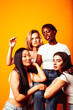 © iordani - diverse multi nation girls group, teenage friends company cheerful having fun, happy smiling, cute posing on yellow background, lifestyle people concept, african-american, asian and caucasian