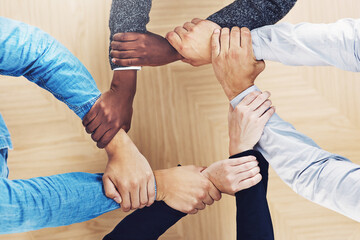 Poster - Keep your links strong. Cropped shot of a group of businesspeople linking their arms in solidarity.