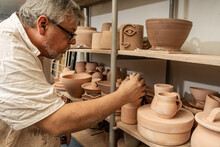 Pottery Craftsman Checking The Pieces And Organizing The Shelves. Handicrafts.