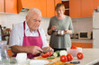 © JackF - Older male and female making healthy eating together at home