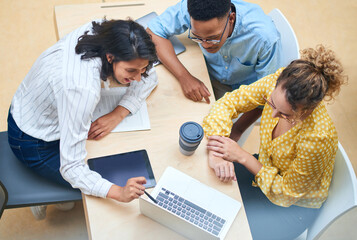 Sticker - Collaboration across departments keeps an organization running smoothly. Shot of a group of young businesspeople using a laptop in a modern office.