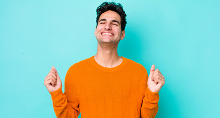 handsome hispanic man looking extremely happy and surprised, celebrating success, shouting and jumping