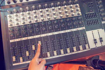 Wall Mural - Production sound engineer woman hands adjusting volume equalizer voice, mixing console. DJ sound engineering working on recording studio mixing voice control.  Producer remix tune music sound record