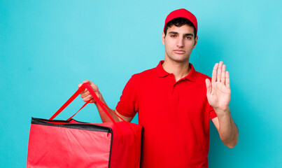 Poster - handsome hispanic man looking serious showing open palm making stop gesture. delivery pizza concept