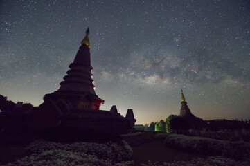 Wall Mural - the milky way galaxy over a sacred temple at doi inthanon national park, chiang mai, thailand. starr