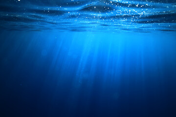 ocean underwater rays of light background, under blue water sunlight