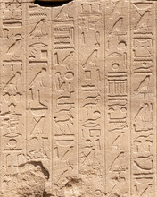 Ancient Egyptian Hieroglyphs On The Stone Walls Of The Karnak Temple In Luxor, Egypt
