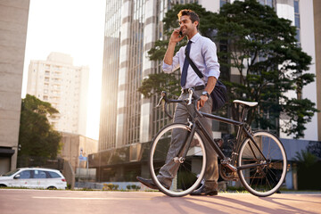 Aufkleber - Business on the go. Shot of a businessman taking a phone call while commuting to work with his bicycle.