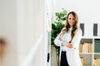 © Westend61 - Smiling businesswoman standing with arms crossed in office