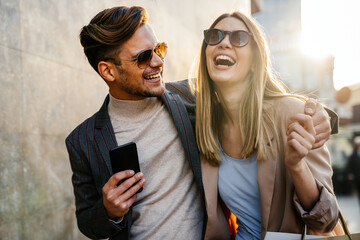 Wall Mural - couple of tourists walking in a city street and shopping together. people shopping fun concept