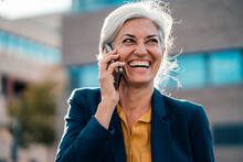 Cheerful Businesswoman With Gray Hair Talking On Smart Phone
