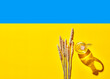 © Westend61 - Ears of wheat by oil bottle on blue and yellow Ukrainian flag