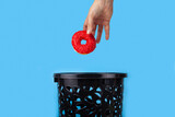 Fototapeta Tulipany - The donut is thrown into the trash can.