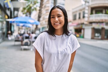 Wall Mural - Young latin girl smiling happy standing at the city.