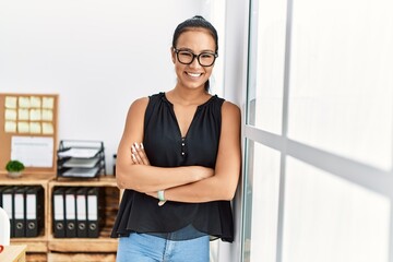 Wall Mural - Young latin woman smiling confident standing with arms crossed gesture at office