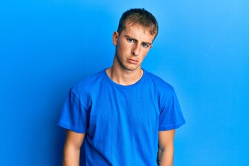 Poster - Young caucasian man wearing casual blue t shirt depressed and worry for distress, crying angry and afraid. sad expression.