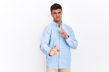 Sticker - Young hispanic man wearing business shirt standing over isolated background disgusted expression, displeased and fearful doing disgust face because aversion reaction.