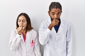 Poster - Young hispanic doctors standing over white background feeling unwell and coughing as symptom for cold or bronchitis. health care concept.