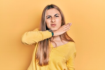 Canvas Print - Beautiful hispanic woman wearing casual yellow sweater cutting throat with hand as knife, threaten aggression with furious violence