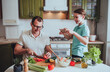 © irena_geo - Father and son cook food at home and record videos for blog on social networks