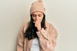 © Krakenimages.com - Young hispanic woman wearing wool sweater and winter hat feeling unwell and coughing as symptom for cold or bronchitis. health care concept.
