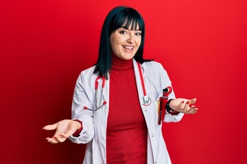 Poster - Young hispanic woman wearing doctor uniform and stethoscope smiling cheerful with open arms as friendly welcome, positive and confident greetings