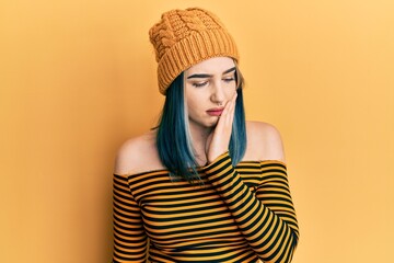 Wall Mural - Young modern girl wearing wool hat touching mouth with hand with painful expression because of toothache or dental illness on teeth. dentist