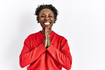 Poster - Young african american woman wearing casual clothes over isolated background praying with hands together asking for forgiveness smiling confident.