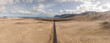 © AmazingAerialAgency - Aerial panoramic view of a straight road crossing the desert valley near Teguise, Lanzarote, Canary Islands, Spain.