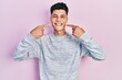 © Krakenimages.com - Young hispanic man wearing casual clothes smiling cheerful showing and pointing with fingers teeth and mouth. dental health concept.