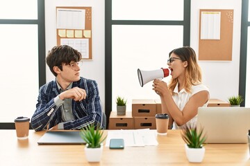 Wall Mural - Businesswoman angry shouting her partner using megaphone at the office.