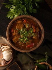 Poster - Vertical photo of a plate of Chashushuli - spicy meat stew with vegetables, Georgian cuisine