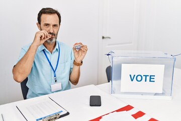 Sticker - Middle age man with beard sitting by ballot holding i vote badge mouth and lips shut as zip with fingers. secret and silent, taboo talking