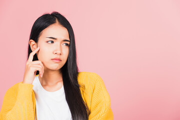 Wall Mural - Portrait Asian beautiful young woman standing chin handle relaxed thinking about something about the question studio shot isolated on pink background, Thai female idea think with copy space