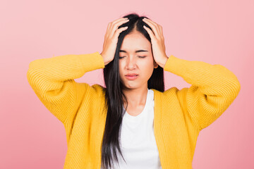 Wall Mural - Portrait of beautiful Asian young woman sad tired strain face holding hold head by hands, female person closed eyes problem she headache, studio shot isolated on pink background