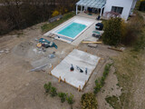 Fototapeta  - Drone shot of pool construction site with concrete pad for heat pump and pool house in garden in austria