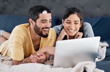 Poster - Lets relax at home and watch movies. Shot of a young couple using a laptop together in bed.